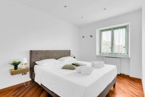 a white bedroom with a large bed with white sheets at Centrale e luminoso-4 persone-Metro M2 e Navigli in Milan