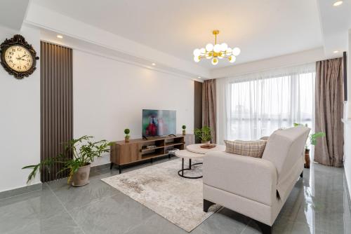 a living room with a chair and a tv at Airy Apartment with Gym, Stunning View in Westlands in Nairobi