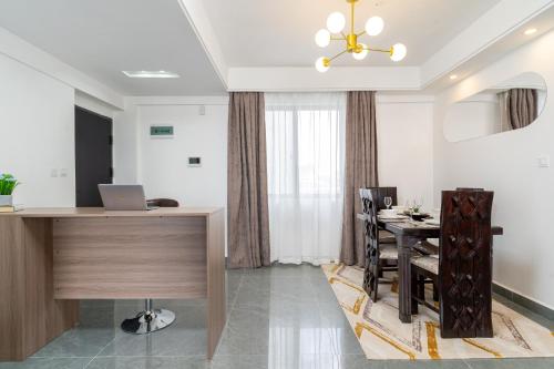 a dining room with a desk and a table with a laptop at Airy Apartment with Gym, Stunning View in Westlands in Nairobi