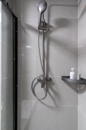 a shower with a shower head in a bathroom at Airy Apartment with Gym, Stunning View in Westlands in Nairobi