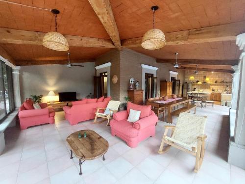 a living room with pink furniture and a table at Casa Quinta Mar, Casa de campo en el Tule, Oaxaca. in Santa María del Tule