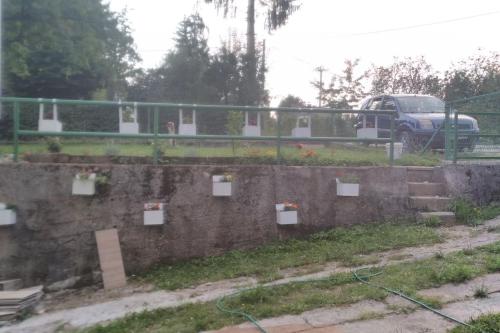 a brick wall with flowers in boxes on it at Cottage Eminem with garden and view of Sarajevo in Hadžići