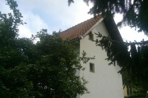 a white building with trees in front of it at Cottage Eminem with garden and view of Sarajevo in Hadžići