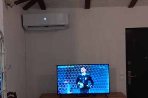 a flat screen tv on a wall in a room at Cottage Eminem with garden and view of Sarajevo in Hadžići