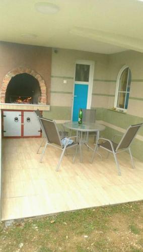 a patio with a table and chairs in a room at Cottage Eminem with garden and view of Sarajevo in Hadžići