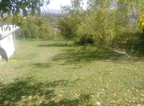 a yard with a fence and a field of grass at Cottage Eminem with garden and view of Sarajevo in Hadžići