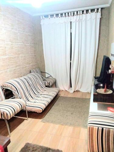 un salon avec un canapé et une fenêtre dans l'établissement Praia Grande canto do forte, à Praia Grande