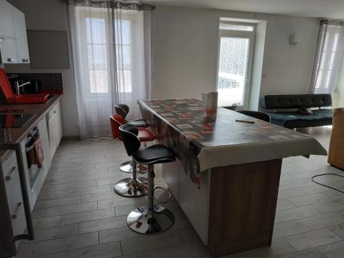 een keuken met een aanrecht en krukken in een kamer bij Maison Noyarey in Noyarey