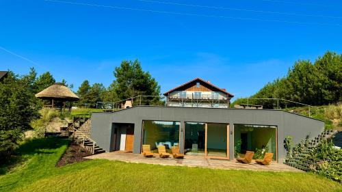 a house on a hill with a deck and chairs at Apartamenty Lobeliowy Port in Borzyszkowy