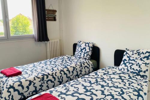 - une chambre avec un lit et une fenêtre avec un couvre-lit dans l'établissement Charmant 3 pièces à Saint-Cyr, à Saint-Cyr-lʼÉcole