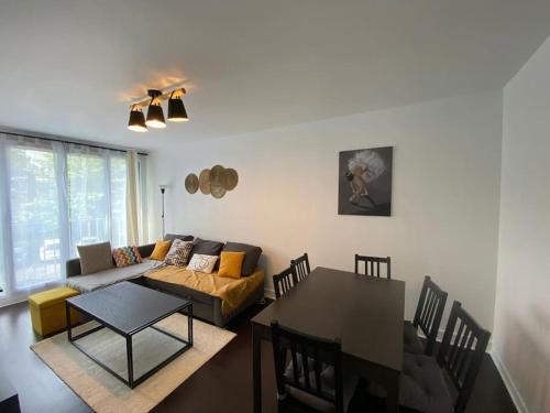 un salon avec un canapé et une table dans l'établissement Charmant 3 pièces à Saint-Cyr, à Saint-Cyr-lʼÉcole