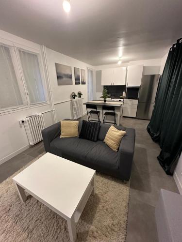 un salon avec un canapé et une table dans l'établissement l'élégant centrale, à Saint-Étienne