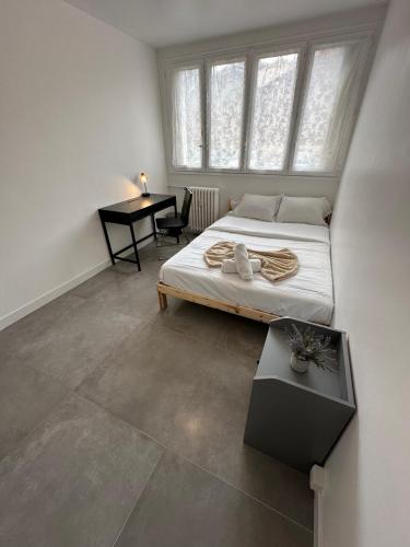 une chambre avec un lit et un bureau dans l'établissement l'élégant centrale, à Saint-Étienne