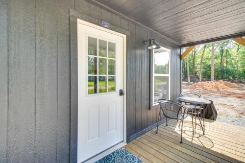 a porch with a table and a white door at Grove Cabin - Walk to Grand Lake o the Cherokees! in Grove