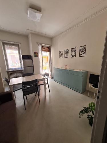 a living room with a table and chairs and a kitchen at casa vacanza il tulipano in Nichelino