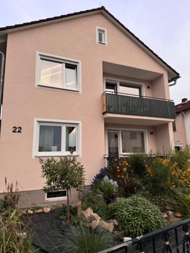 a pink house with a garden in front of it at Helle und gemütliche Ferienwohnung in Lorsch in Lorsch