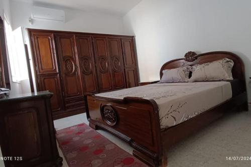 a bedroom with a bed with a wooden headboard at Maison La brise Marine in Mteurch