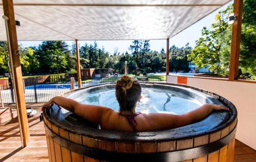 a woman in a hot tub in a barrel at Sapphire Springs Holiday Park and Thermal Pools in Katikati