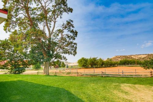 a tree in a field next to a fence at Ranch House in Boulder! Gateway to Nearby Parks! in Boulder Town