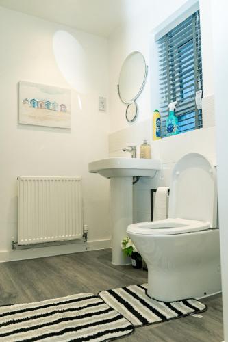 a bathroom with a toilet and a sink at The Grace House Entire 4bed detached in Peterborough