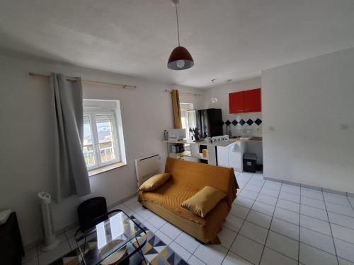 un salon avec un canapé et une cuisine dans l'établissement T2 le terminus, face gare , wifi, à Agen