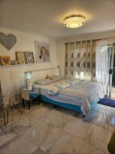 a bedroom with a bed and a chandelier at Cute comfortable, quiet studio 11 with Carpark in Auckland