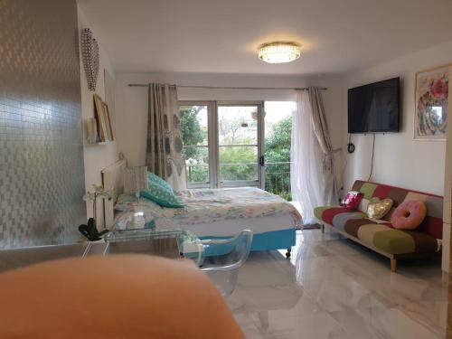 a living room with a bed and a window at Cute comfortable, quiet studio 11 with Carpark in Auckland