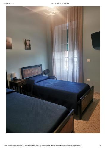 a bedroom with two beds and a television in it at B&B Zì Camillo in Sicignano degli Alburni