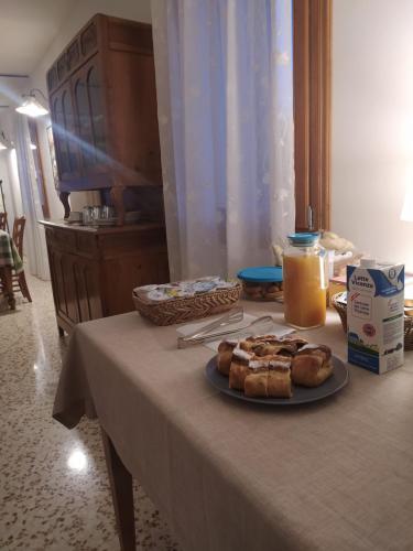 a table with a plate of pastries and a bottle of milk at Casa Agricola Amicizia in Poiana Maggiore