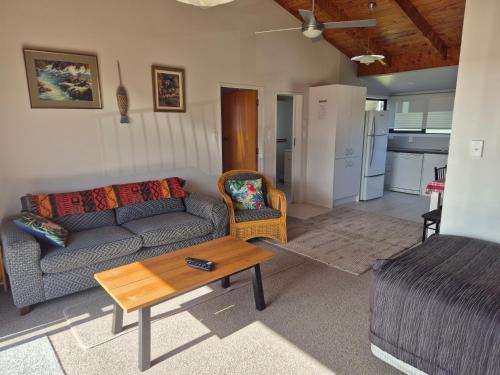 a living room with a couch and a coffee table at Blue Marlin Apartments in Whitianga