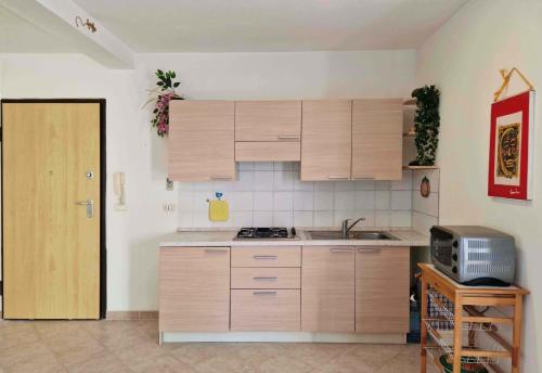 a kitchen with wooden cabinets and a sink and a door at Tommy's Apartment in Santa Maria