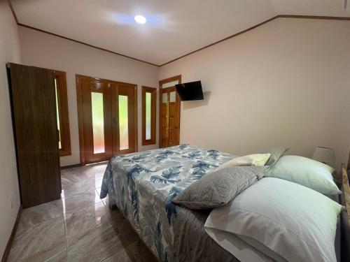 a bedroom with a bed and a flat screen tv at Chilamate Room 2 in Tortuguero