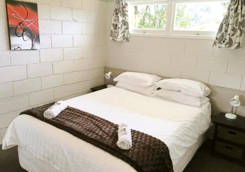 a bedroom with a bed with two towels on it at Sapphire Springs Holiday Park and Thermal Pools in Katikati