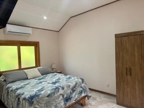 a bedroom with a bed and a wooden cabinet at Chilamate Room 2 in Tortuguero