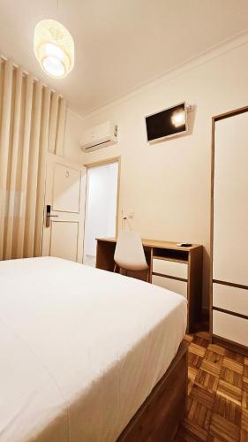 a bedroom with a bed and a desk and a chair at Rooms4you 1 in historic center of Braga in Braga