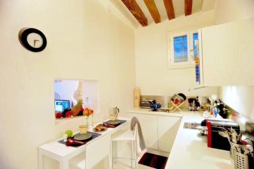 uma cozinha com balcões brancos e um relógio na parede em Ca' Vittoria em Veneza