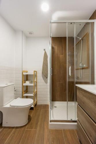 a bathroom with a toilet and a glass shower at Casa rural las golondrinas in Quesa