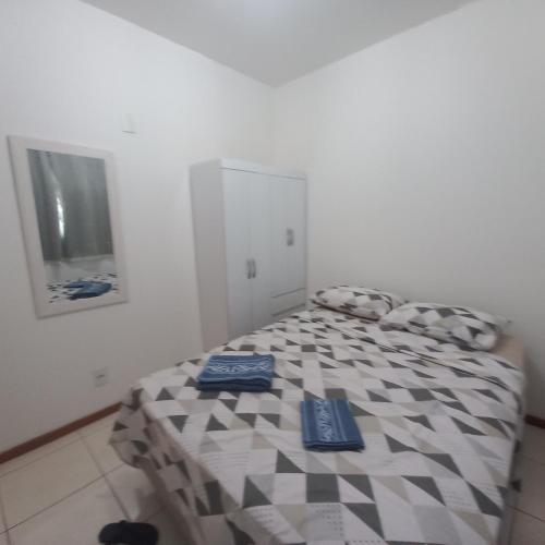 a bedroom with a bed with a checkered bedspread at Quarto Nº 1 Taguatinga Sul garagem wi-fi - 1 a 2 hospedes sem taxas in Brasilia