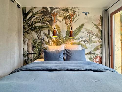 a bedroom with a blue bed with a tropical wallpaper at Appartement avec Jacuzzi - Climatisation - Parking in Bordeaux