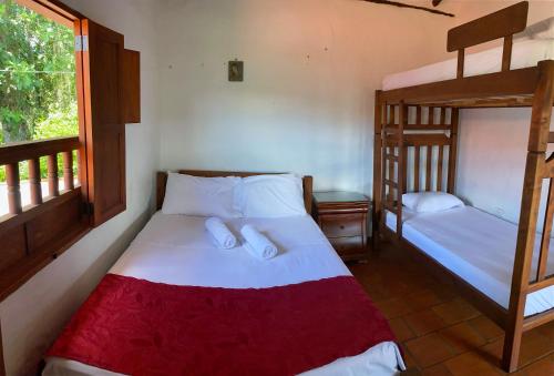 a bedroom with two bunk beds and a window at Hostal Villa San Rafael in Barichara