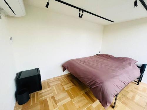 a bedroom with a bed and a television in it at 1棟貸し ビーチまで徒歩3分 プライベートバレルサウナ有り 近くにコンビニ スパ有り in Jōnouchi