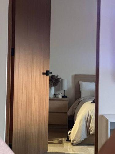 a door leading to a bedroom with a bed at Departamento acogedor con vista al mar y alberca in Conchal