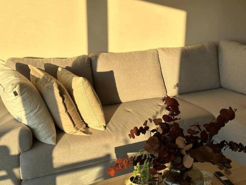 a couch with pillows and a table in a living room at Departamento acogedor con vista al mar y alberca in Conchal