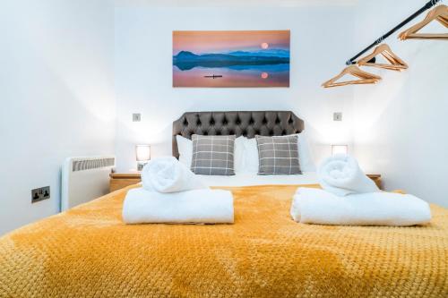 a bedroom with a large bed with two white towels at Spacious 2-Bed Apartment in Liverpool Cavern Quarter - Minutes from Bars and Live Music by Garudy Serviced Apartments in Liverpool