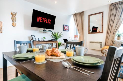 a dining room with a table with food and orange juice at Spacious 2-Bed Apartment in Liverpool Cavern Quarter - Minutes from Bars and Live Music by Garudy Serviced Apartments in Liverpool