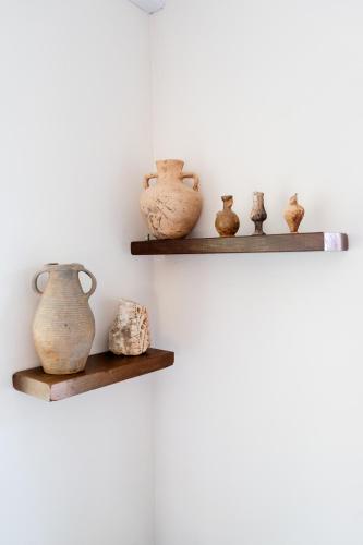 a group of vases sitting on shelves on a wall at Blue Horizon Kastellorizo in Meyisti