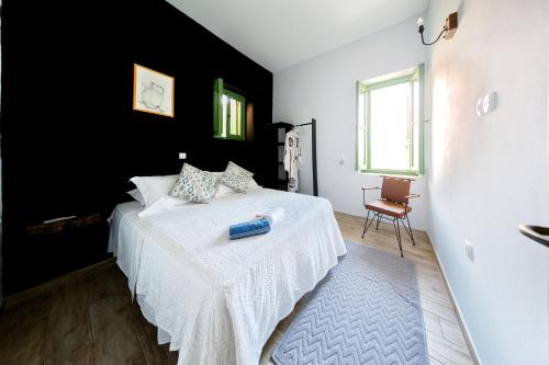 a bedroom with a white bed and a black wall at Blue Horizon Kastellorizo in Meyisti