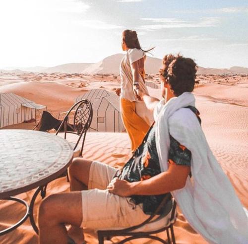 two women sitting at a table in the desert at Sahara Zen Luxury Camp in Merzouga