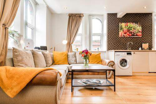 a living room with a couch and a table at Spacious 2-Bed Apartment in Liverpool Cavern Quarter - Minutes from Bars and Live Music by Garudy Serviced Apartments in Liverpool