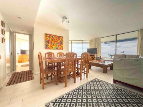 a living room with a dining room table and chairs at Departamento Grande en San Alfonso del Mar 4D 3B 2EST in Algarrobo